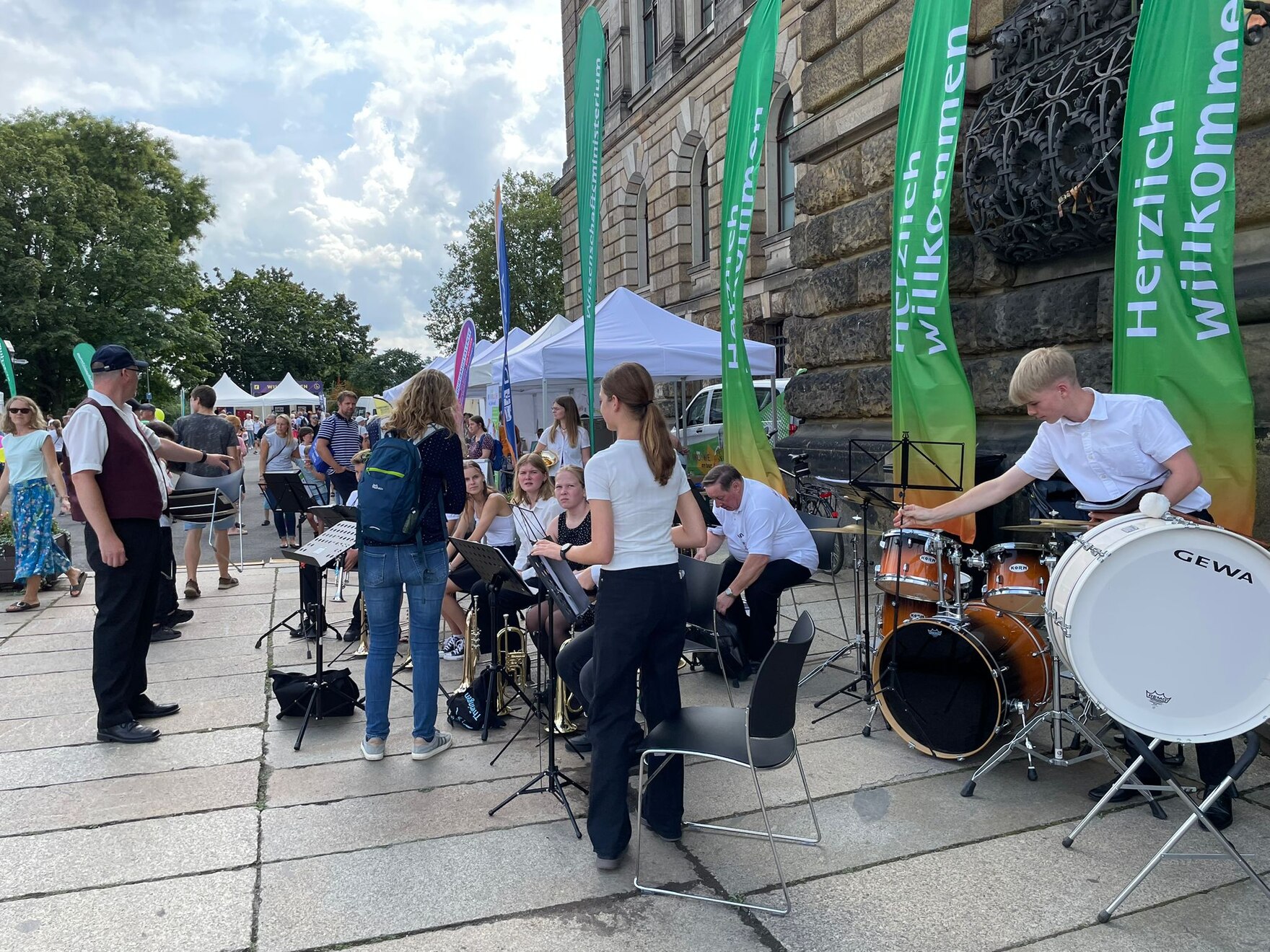 Mehrere Personen mit Instrumenten bereiten sich auf ein Konzert vor.